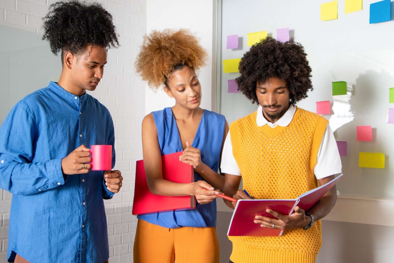 a group of people standing in front of a whiteboard